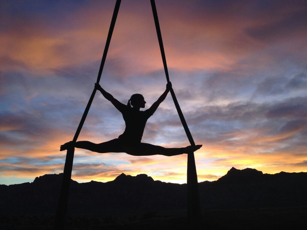 beginner practicing aerial yoga at home using an aerial hammock and yoga swing setup